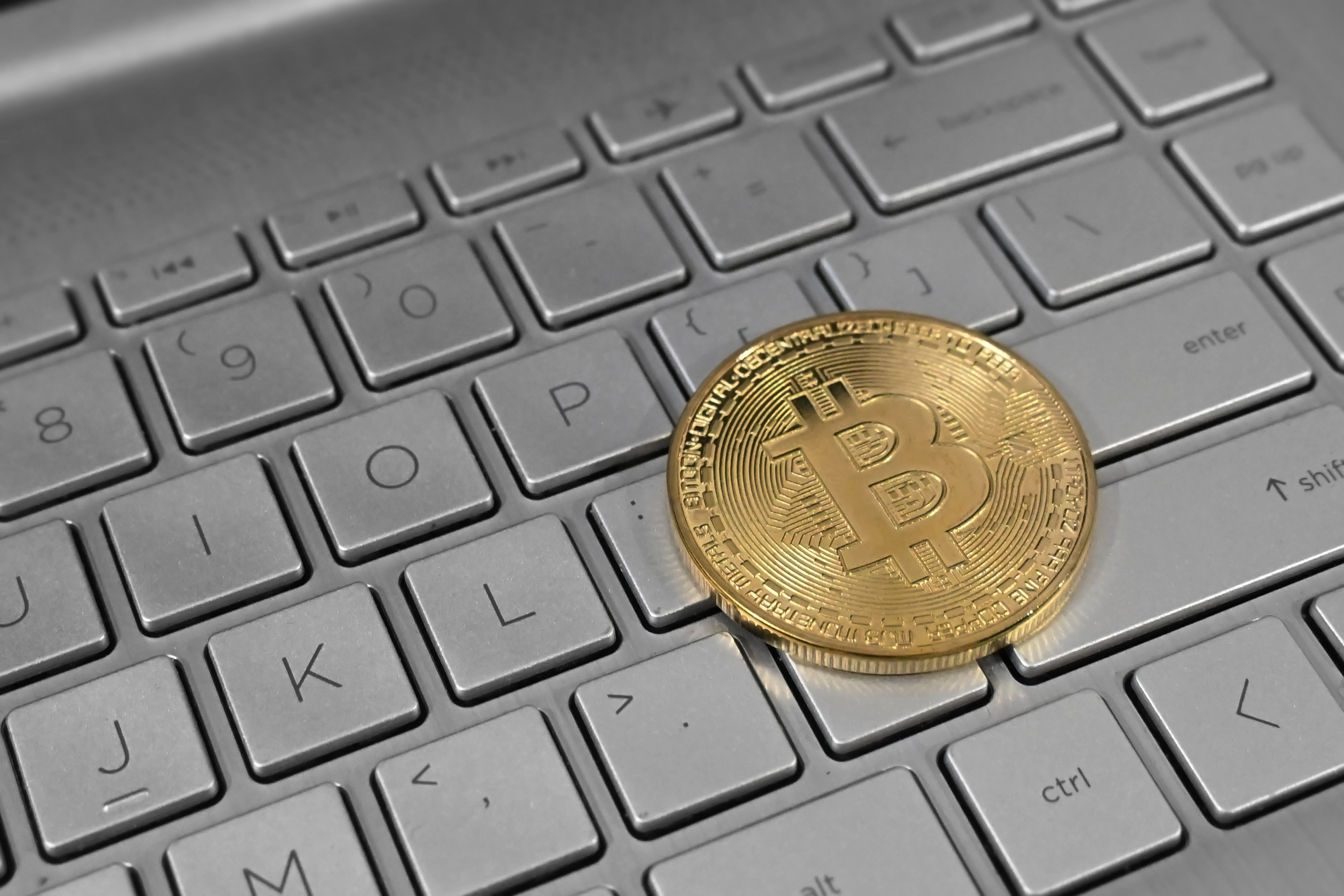 Close-up photograph of a Bitcoin coin on a laptop keyboard